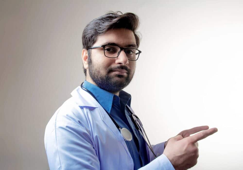 man in a blue shirt wearing a white coat
