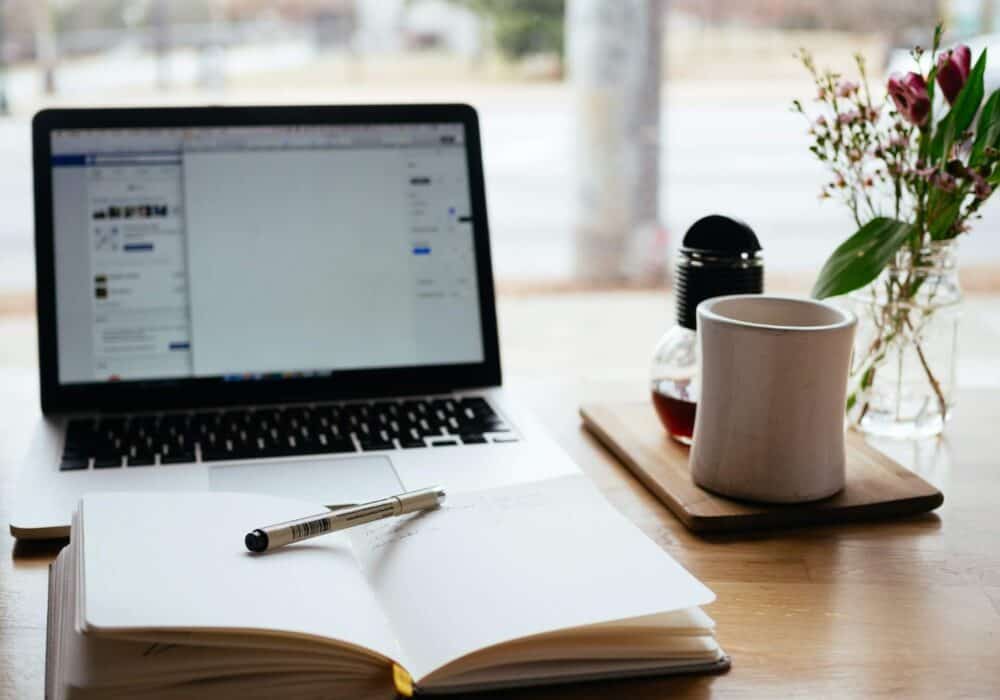 Open notebook in front of a laptop